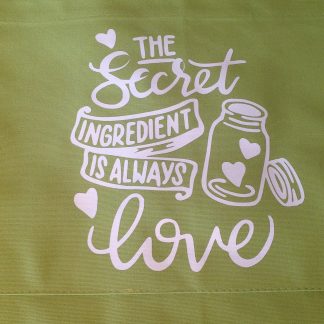 Uniseks schort - 90cm - limoengroen - bedrukt "The secret ingredient is alway’s love"